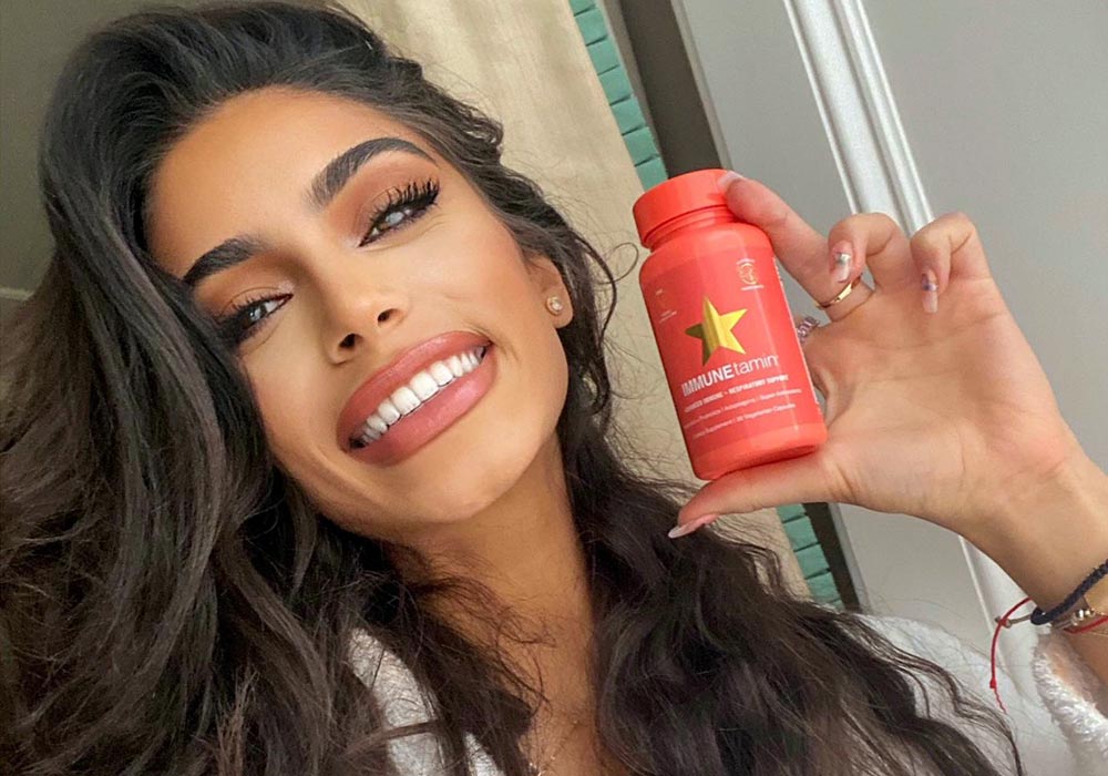 Long brown haired customer holding IMMUNEtamin bottle