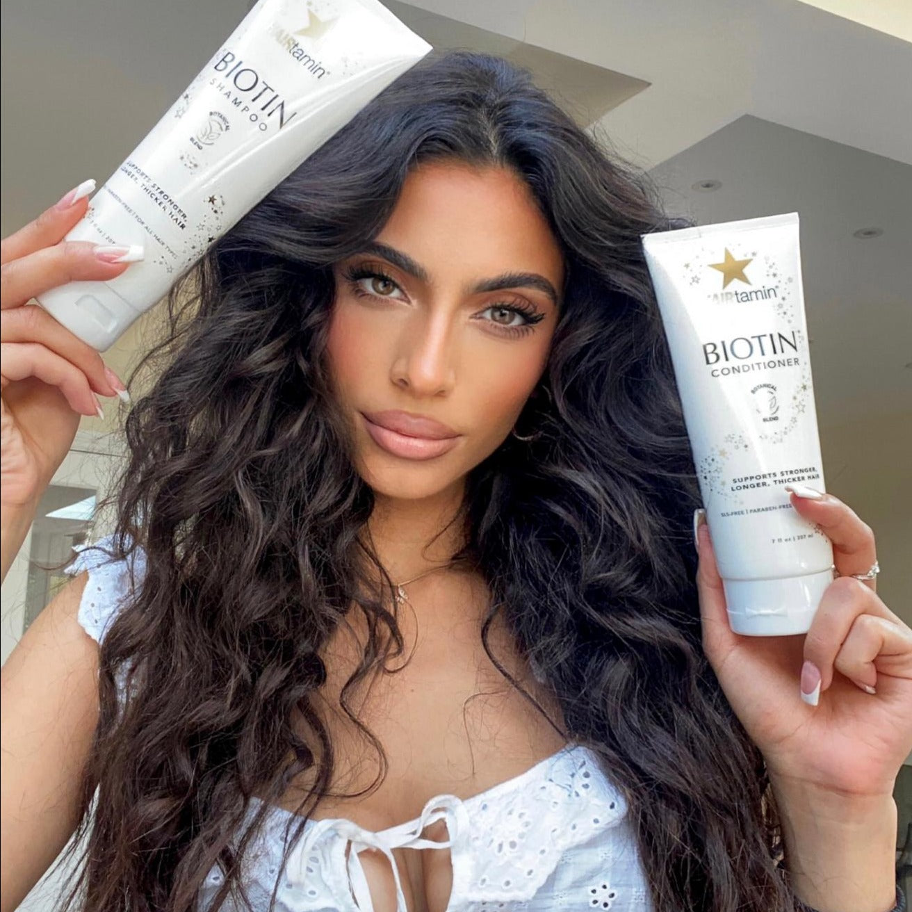 Customer holding biotin shampoo and conditioner